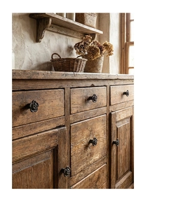 Detail of vintage flower-shaped cast iron handle mounted on rustic wooden cabinet door