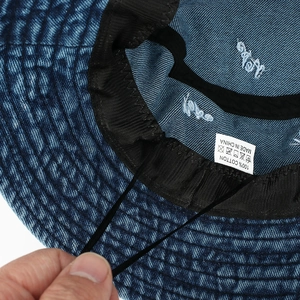 Détail de l'intérieur d'une casquette montrant l'étiquette 100% coton et coutures