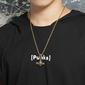 Detail of gold Viking Mjolnir hammer pendant with intricate engravings on twisted chain