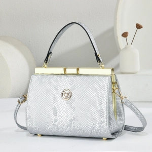 Close-up of silver snakeskin textured handbag with premium gold hardware and logo
