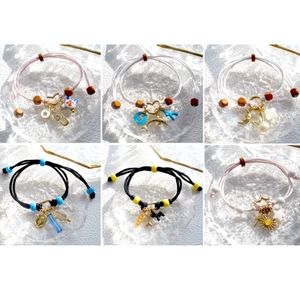 Macro view of six diverse handmade braided bracelets with acrylic and alloy charms