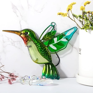 Detail of green hummingbird suncatcher with metal wings and hanging crystal prism