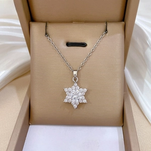 Macro detail of snowflake pendant necklace with cubic zirconia on velvet background