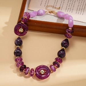 Detailed close-up of purple acrylic marble beads and gold spacers on a vintage necklace