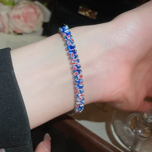 Vue détaillée du bracelet en émail coloré avec motifs rouges et bleus sur chaîne argentée