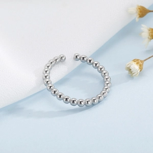 Gros plan détaillé d'une bague à perles argentée avec un design ondulé minimaliste réglable
