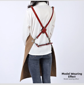 Detail of adjustable leather X-back straps on a heavy-duty canvas work apron