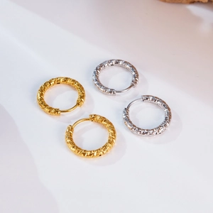 Detailed macro view of gold and silver hoop earrings with textured hammered finish