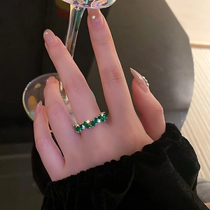 Détail de la bague plaquée or avec zircons verts rectangulaires portée par un mannequin
