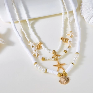 Vue détaillée du collier multicouche en perles avec pendentifs étoile de mer dorés