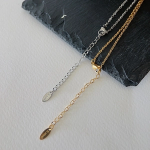 Detail of lobster clasp and S.STEEL engraved tag on gold and silver horseshoe necklace