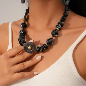 Detail of chunky black marble acrylic beads with gold spacers on a long necklace