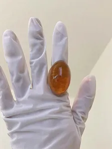 Detailed close-up of an amber oval resin ring with smooth texture and natural patterns