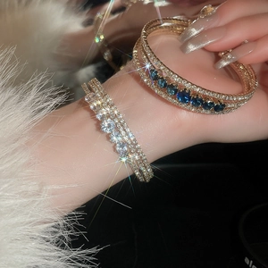 Detailed shot of multi-layer gold bracelet with blue gemstones and sparkling zircons