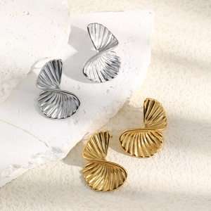 Detailed view of twisted shell earrings with vertical stripes in gold and silver finish