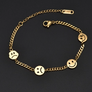 Bracelet en acier inoxydable doré avec breloques visages souriants et tristes sur fond noir