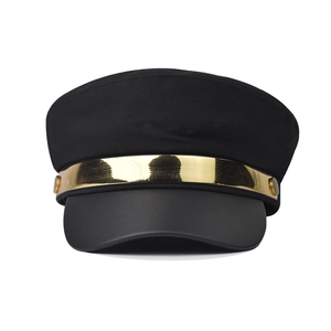 Detail of black baker boy hat featuring a metallic gold band and side buttons