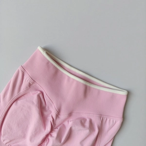 Detail view of pink yoga shorts featuring high-waisted ribbed band and scrunch butt design
