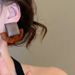 Retro geometric square wood and amber resin earrings worn by a model in a close-up view