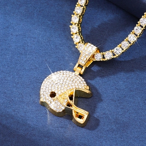 Macro detail of gold American football helmet pendant with shimmering cubic zirconia