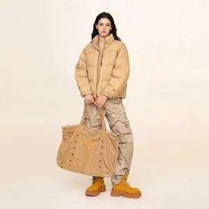 Beige padded mountaineering jacket with camouflage cargo pants and canvas tote bag