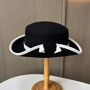 Détail d'un chapeau vintage en feutre de laine avec ruban blanc et décoration de rose 3D