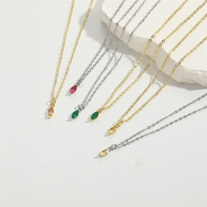 Elegant gold and silver necklaces with colorful marquise-cut zircon pendants on stone