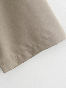 Detailed macro view showing khaki linen texture and precise stitching of the two-piece set