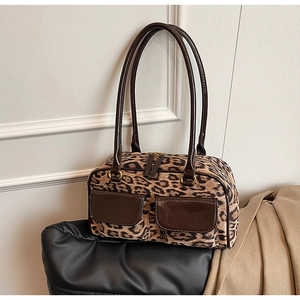 Detail view of leopard print shoulder bag with two front pockets and gold hardware buckles