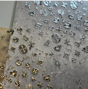 Macro shot of 3D embossed gold and silver nail stickers with star and moon patterns