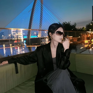 Chic model wearing oversized gold earrings and a vintage ring with a black blazer