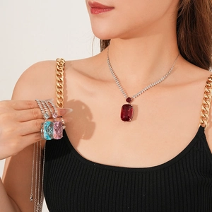 Close-up of elegant necklaces featuring vibrant red, blue, and pink square gemstones