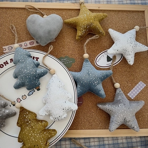 Macro detail of plush Christmas ornaments with silver dots, wooden beads and twine rope