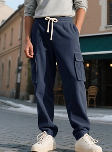 Detail of dark blue corduroy joggers featuring large cargo pockets and white drawstrings