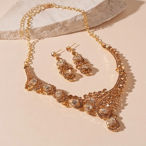 Detailed macro shot of vintage gold teardrop necklace set with champagne crystals