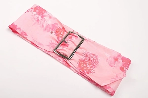 Close-up of pink floral print fabric belt with a silver rectangular metal buckle