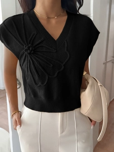 Close-up of black V-neck knit sweater vest featuring unique 3D floral embroidery