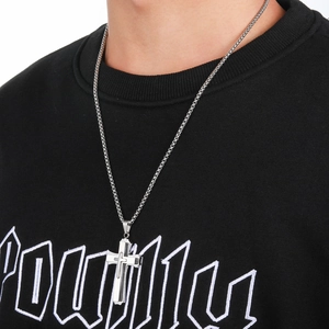 Close-up of a silver triple-layered stainless steel cross pendant on a box chain necklace