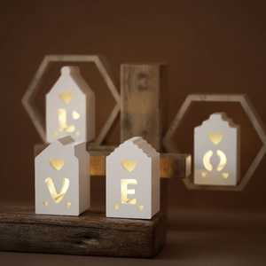 Close-up of LOVE letters mini house light with warm LED glow on rustic wood