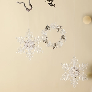 Hanging transparent acrylic snowflake ornaments and glitter wreaths for Christmas tree decor