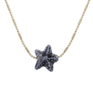 Gold beaded chain necklace featuring a blue ceramic starfish pendant on white background