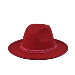 Detail of red wide-brim wool fedora hat featuring a bold pink chain link decorative band