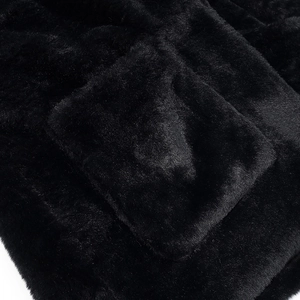 Close-up of premium black faux fur texture and seam detail on a padded winter jacket