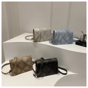 Dettaglio di quattro piccole borse trapuntate nei colori bianco, blu, marrone e nero