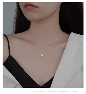 Detailed close-up of a silver butterfly pendant necklace with white mother of pearl inlay