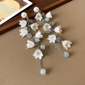 Detail of lily of the valley tassel earrings with pearls and grey textured beads