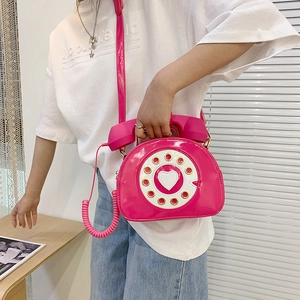 Unique magenta vintage telephone shaped crossbody bag with a heart dial and patent leather