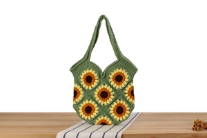 Detailed view of hand-crocheted green bag featuring yellow sunflower pattern units