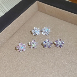 Detailed view of elegant snowflake zircon stud earrings in silver, pink, and purple colors