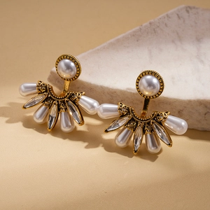 Boucles d'oreilles baroques en éventail avec perles blanches et cristaux sur marbre